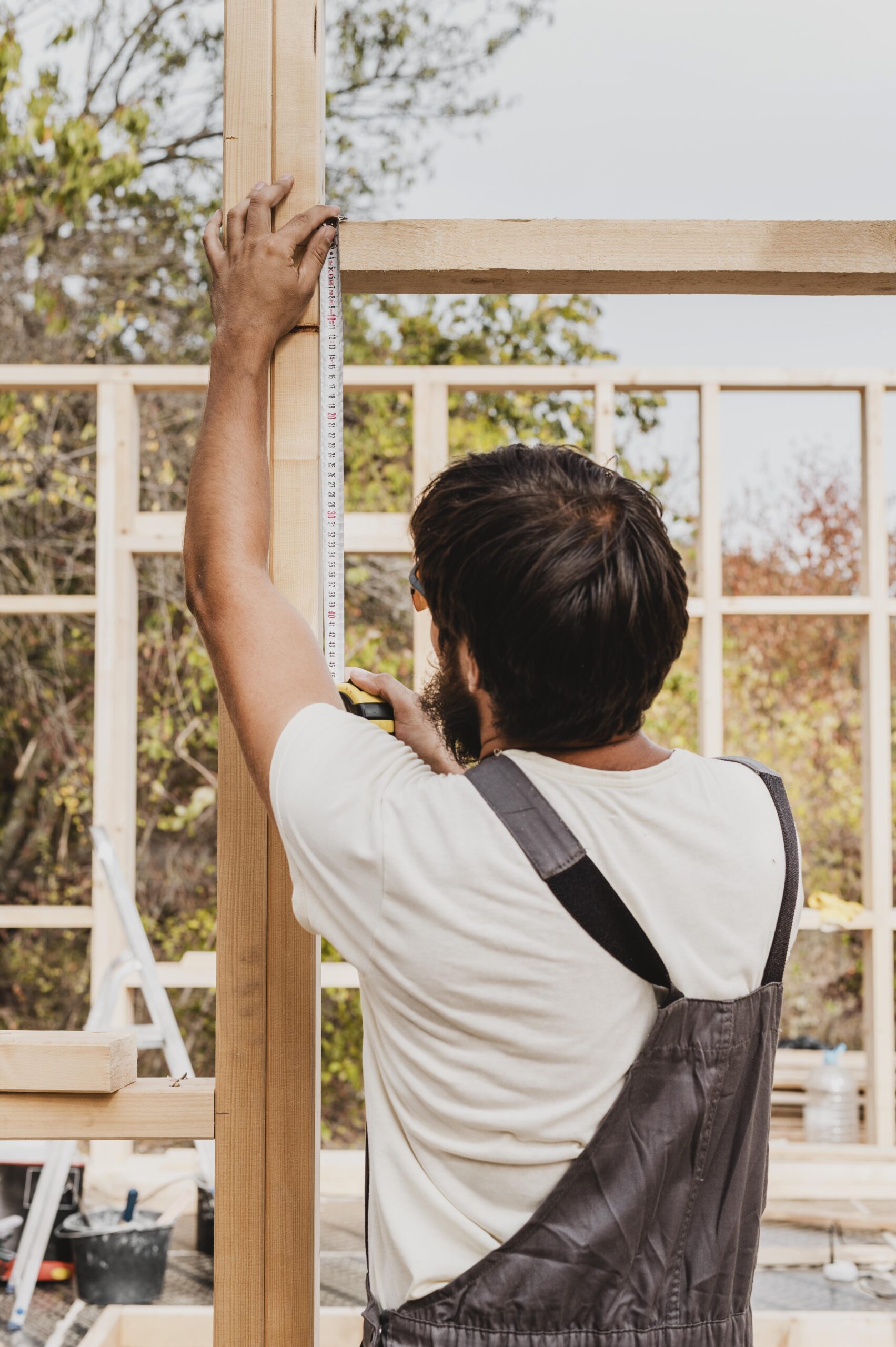 carpenter man using tape measure from shot scaled