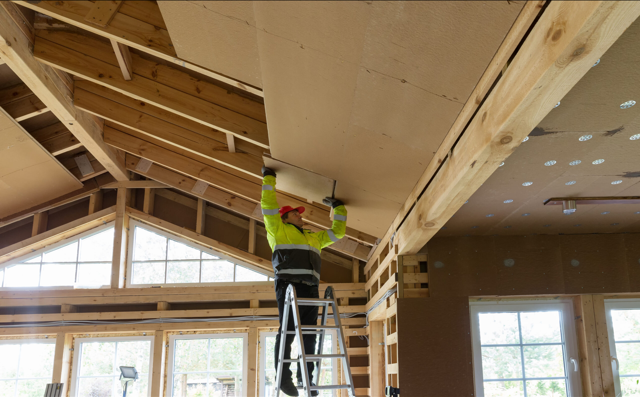 construction worker thermally insulating eco wooden frame house scaled